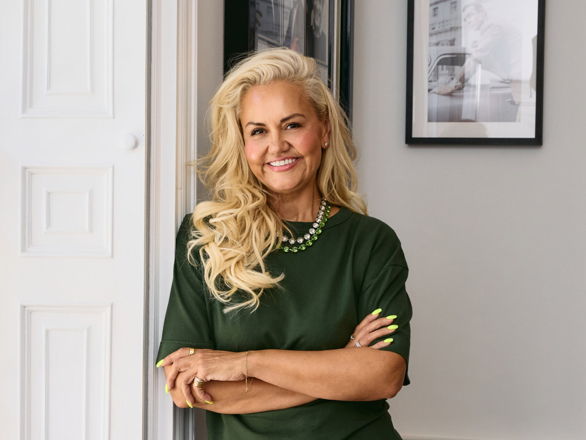 Portrait of Caroline Hirons smiling with arms crossed, wearing a green top and green necklace.