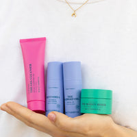 Skin Rocks by Caroline Hirons | Hand holding skincare set: gel cleanser, retinoid serum, facial oil, moisturiser
