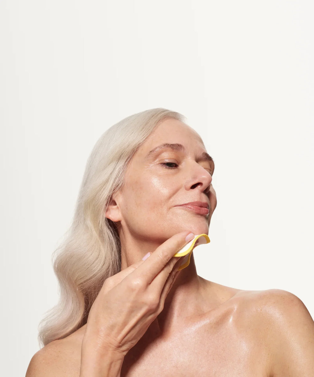 Skin Rocks by Caroline Hirons | Woman using yellow cloth for gentle skincare routine on glowing skin