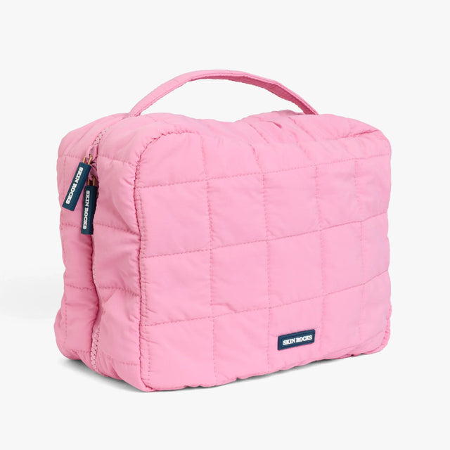 Skin Rocks by Caroline Hirons | Pink quilted travel makeup bag with handle and brand tags
